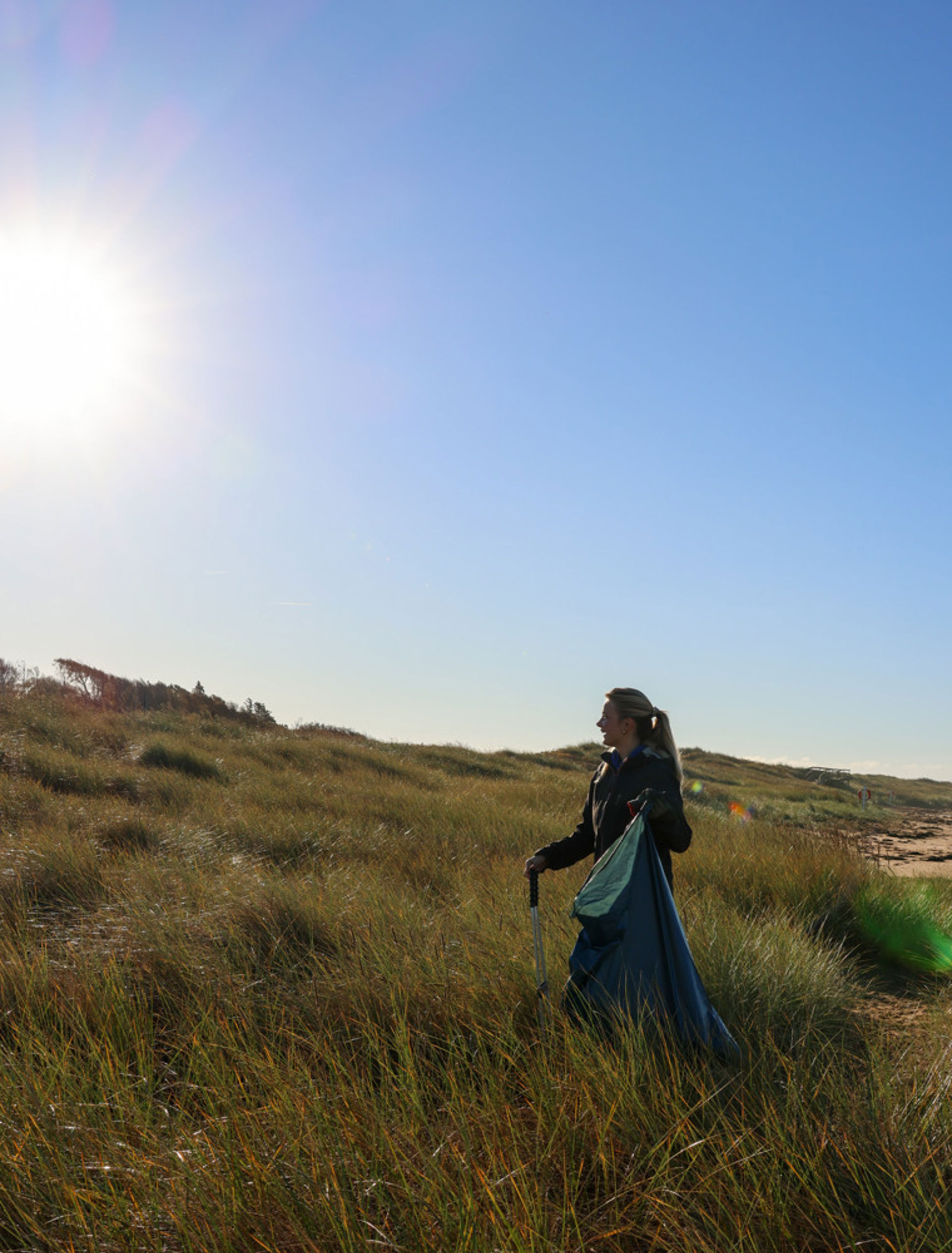 Emma från CleanSea letar skräp bland sanddynorna i Påarp.